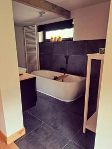 een badkamer met een wit bad in een kamer bij B&B De Geythoek in Sijsele