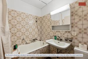 bagno con lavandino, vasca e specchio di Spacious Apartment in Zurich a Zurigo