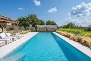 einen Pool mit blauem Wasser im Hinterhof in der Unterkunft Villa Charlotte for 14 persons with 73m2 Pool in Central Istria in Radovani