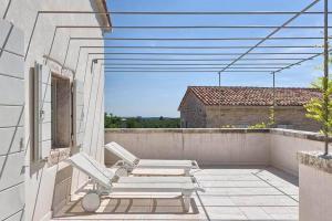 eine Terrasse mit 2 Liegestühlen auf dem Balkon in der Unterkunft Villa Charlotte for 14 persons with 73m2 Pool in Central Istria in Radovani