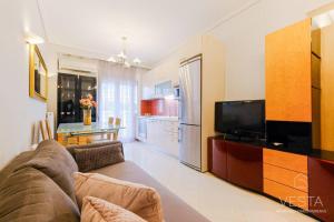 een woonkamer met een bank en een flatscreen-tv bij Lavender 2bdrm Apartment, Vesta Philoxenia in Thessaloniki