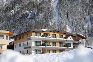 索爾登的住宿－A CASA Granat，雪覆盖的山前的建筑物