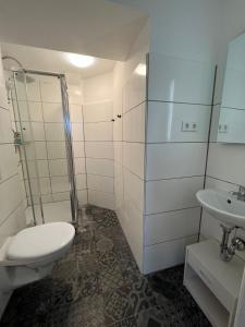 a bathroom with a toilet and a shower and a sink at City Flats Dortmund in Dortmund