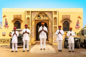 Un groupe d'hommes priant devant un bâtiment dans l'établissement Desert Trails Khuri, à Kūri