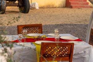 une table avec des assiettes et des verres au-dessus dans l'établissement Desert Trails Khuri, à Kūri