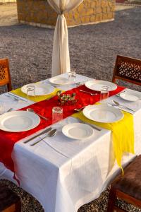 une table avec des assiettes et des verres au-dessus dans l'établissement Desert Trails Khuri, à Kūri