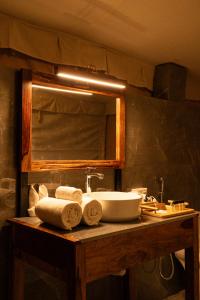 La salle de bains est pourvue d'un lavabo, d'un miroir et de serviettes. dans l'établissement Desert Trails Khuri, à Kūri