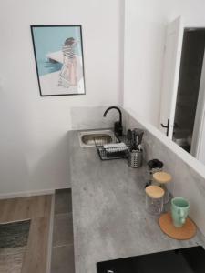 una cucina con lavandino e bancone con sgabelli di studio 1/2 lesage#garedereims a Reims