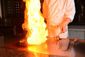 a chef is preparing food on a counter with fire at Bayside Hotel Azur Takeshiba in Tokyo