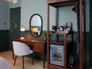 a room with a desk and a mirror and a chair at Dog and Partridge by Greene King Inns in Bury Saint Edmunds