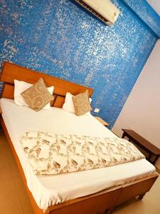 a bedroom with a bed with a blue wall at Hotel Braj Haveli in Jaipur
