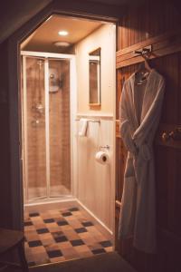 a bathroom with a shower and a robe on a rack at Press Mains Farm Cottages in Eyemouth