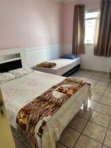 um quarto com duas camas num quarto com uma janela em Apartamento Sol da Praia do Morro em Guarapari