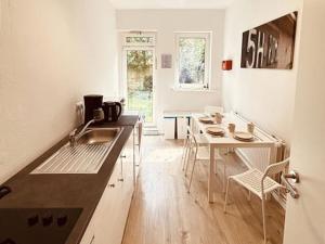 cocina con fregadero y mesa con sillas en Nice Apartment in Halstenbek, en Halstenbek