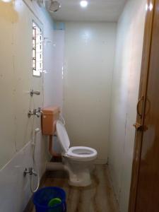 baño pequeño con aseo y ventana en Blue Cherry Guest House en Calcuta