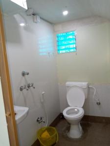 baño con aseo y lavabo y ventana en Blue Cherry Guest House en Calcuta