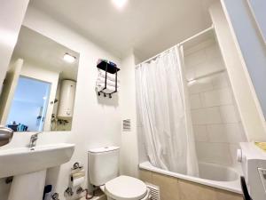 a white bathroom with a toilet and a sink at Cómodo departamento con piscina en Los Ángeles in Los Ángeles