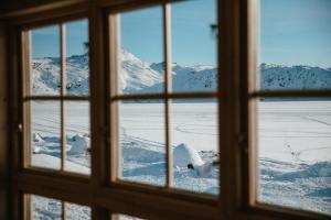 a view of a snowy mountain through a window at Igloo Lodge in Ilulissat