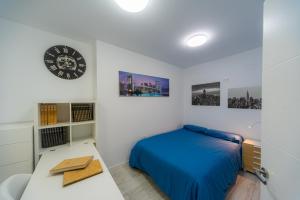 1 dormitorio con 1 cama y reloj en la pared en Chalet con piscina a 20 minutos de Sierra Nevada, en Cenes de la Vega