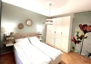 a bedroom with a white bed and a white cabinet at Dreamy Apartment Near To The Center in Sofia