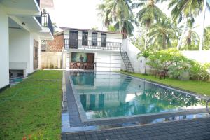 a swimming pool in front of a house at Villa71 in Galle