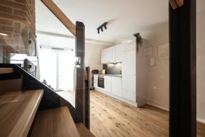 a kitchen with white cabinets and a wooden floor at Luxury Penthouse on the Lake in Überlingen