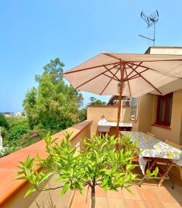 um pátio com uma mesa e um guarda-sol numa varanda em Casa Giusy em Terrasini