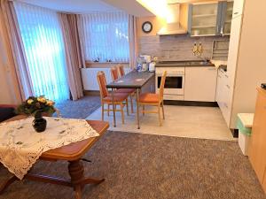 a kitchen and dining room with a table and chairs at FEWO Angelika Behindertengerecht in Rohrbach