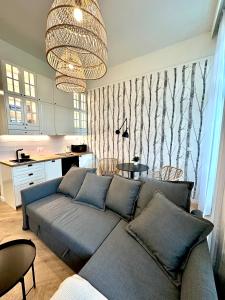 uma sala de estar com um sofá azul e uma cozinha em Premium Apartment - Old Town Jana Pawła II em Breslávia