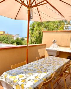 uma mesa e cadeiras com um guarda-sol numa varanda em Casa Giusy em Terrasini