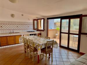 uma sala de jantar com uma mesa e cadeiras numa cozinha em Casa Giusy em Terrasini