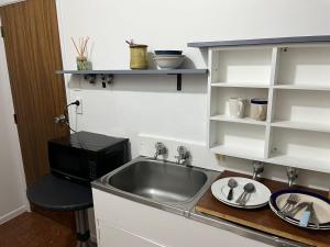 a kitchen with a sink and a microwave at Totara Vale, Free Coffee, parking and wifi, near Glenfield Mall and highway 18,1 in Auckland