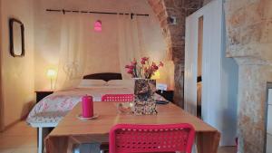 1 dormitorio con 1 cama y 1 mesa con flores en Dammuso Romantico, en Scicli