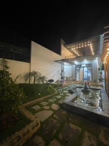 a building with a fountain in front of it at night at Á Châu homestay in Ấp Thanh Sơn (1)