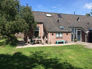 a brick house with a picnic table in a yard at Apartment Zus en Zo in Uffelte