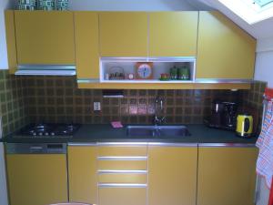 a kitchen with yellow cabinets and a sink at Apartment Zus en Zo in Uffelte