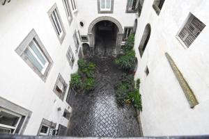 an alley way between two buildings with plants at Corte Capomazza Appartamenti in Naples