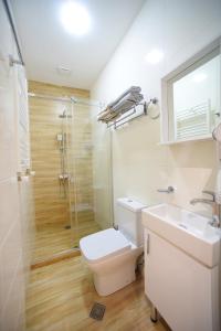 a bathroom with a toilet and a shower and a sink at City Lux Hotel in Tbilisi City