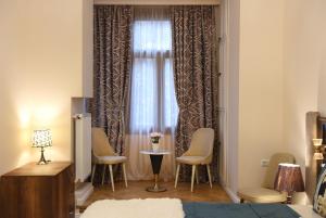 a bedroom with a window with chairs and a table at City Lux Hotel in Tbilisi City