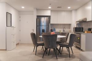 a kitchen with a table and chairs and a refrigerator at New 2 bedroom entire apartment in Madinat Jumeirah Living in Dubai