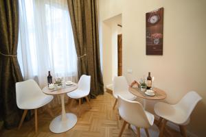 a dining room with two tables and white chairs at City Lux Hotel in Tbilisi City