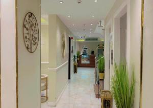 a hallway with plants and a clock on the wall at غيمة للشقق الفندقية in Jeddah