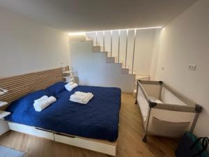 a bedroom with a blue bed and a staircase at La Casina a Treggiaia in Treggiaia