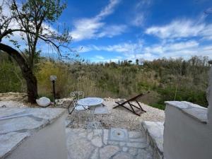 eine Terrasse mit einem Tisch, einem Tisch und einem Baum in der Unterkunft La Casina a Treggiaia in Treggiaia