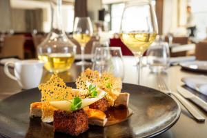 une assiette de nourriture sur une table avec des verres à vin dans l'établissement Best Western Plus Villa Saint Antoine Hotel & Spa, à Clisson