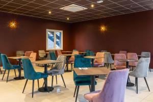 Best Western Hotel & SPA Pau Lescar Aeroport في ليسكار: غرفة بها طاولات وكراسي في غرفة