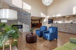 a lobby with blue chairs and a fireplace at Comfort Suites Auburn Hills-Detroit in Auburn Hills