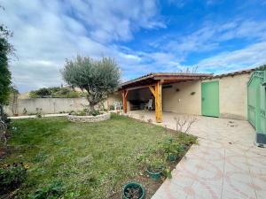 una casa con una puerta verde y un patio en Villa Anatole - parking privé - 900m Cité Médiévale, en Carcassonne