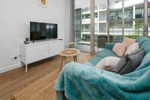 ein Wohnzimmer mit einem blauen Sofa und einem TV in der Unterkunft Stylish 2BR 2BA Apartment in Bowden Bliss in Bowden