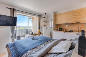 um quarto com uma cama grande e uma cozinha em Sea view & spa suite: 3min beach em Fréjus
